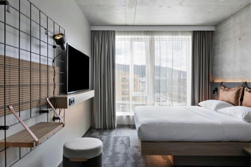 a hotel room with a bed and a large window at Moxy Aarhus in Aarhus