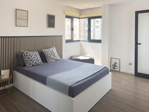 a bedroom with a large bed and a chair at Modern 2-bdr apt with rooftop pool - LCGR in Praia