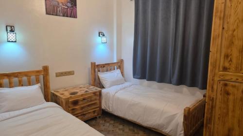 two twin beds in a room with a window at Maison marhaba2 app 3 in Agadir