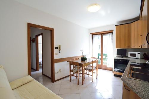 a kitchen with a table and chairs in a room at Apart Erica in Comano Terme