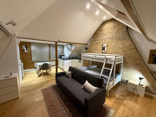 a living room with a bunk bed and a brick wall at 3 x Studios Golden Manor in Hanwell