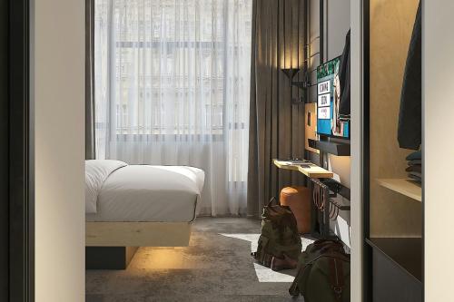 a bedroom with a bed and a window at Moxy Belgrade Skadarlija in Belgrade