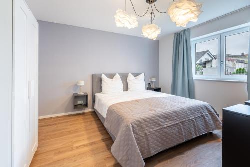 a bedroom with a large bed and a window at Tonirooms 2 Zimmer Apartment Eisvogel in Straubing