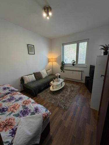 a living room with a bed and a couch at Apartmán pod Čebraťom in Ružomberok