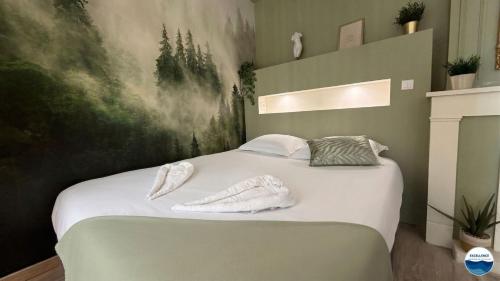 a bedroom with a bed with white towels on it at La Suite Vegetale Studio Prestige Hyper Centre in Mâcon