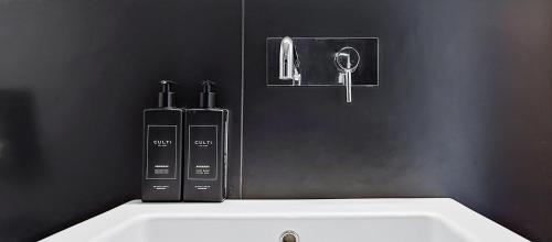 two bottles are sitting on top of a white sink at Home BB Milano in Milan