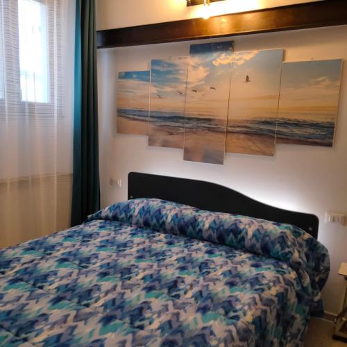 a bedroom with a bed and paintings on the wall at Appartamento Giuse Mari in Suvereto