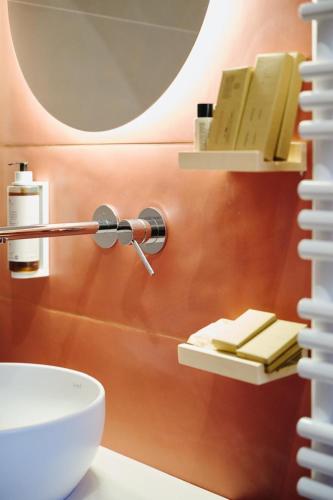 a bathroom with a sink and a shelf with books at Casa Lomè - Dimora Vacanze in Conversano