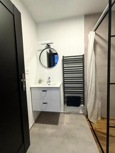 a bathroom with a white sink and a mirror at Apartmán Gabi in Lučenec
