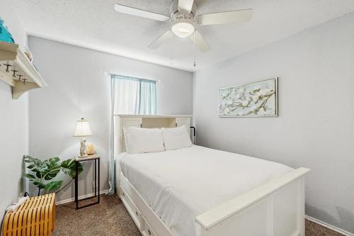 a bedroom with a white bed and a ceiling fan at Hidden Treasure in Corpus Christi