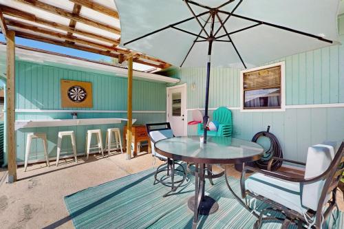 a patio with a table and an umbrella at Hidden Treasure in Corpus Christi