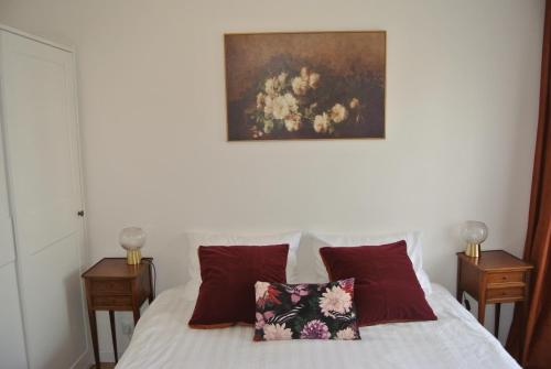 a bedroom with a bed with a painting on the wall at Le Jardin de Madison in Cessy