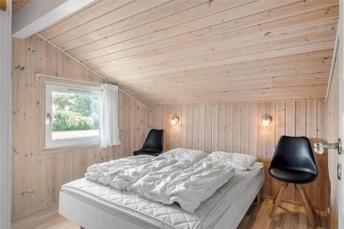 a bedroom with a bed and two chairs in it at OH118-Storvorde-Kongeornen-32 in Storvorde