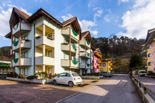 a white car parked in front of a building at Apart Erica in Comano Terme
