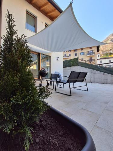 a patio with two benches and a grill at Chalet La coccola di Lulù in Molina di Ledro