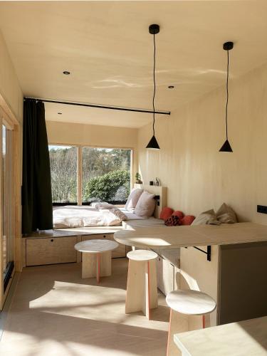 a room with a bed and a table and chairs at Tiny House 2 mit Garten in der Lüneburger Heide in Soltau
