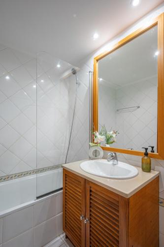 a bathroom with a sink and a shower at Garajau Terrace Apartment - Pool and Free Parking in Caniço