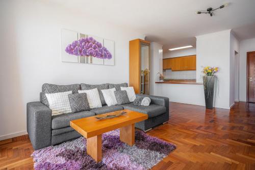 a living room with a couch and a table at Garajau Terrace Apartment - Pool and Free Parking in Caniço
