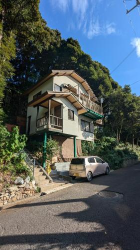 a house with a car parked in front of it at 伊根の宿 汐風 Shiokaze in Nomuro