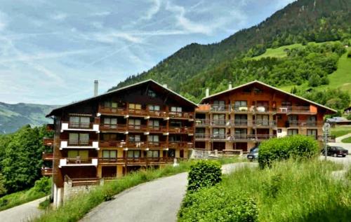 two buildings on a road next to a mountain at Arêches, 4 pers, télésiège à 5 mn à pied, grande terrasse en RDJ in Beaufort