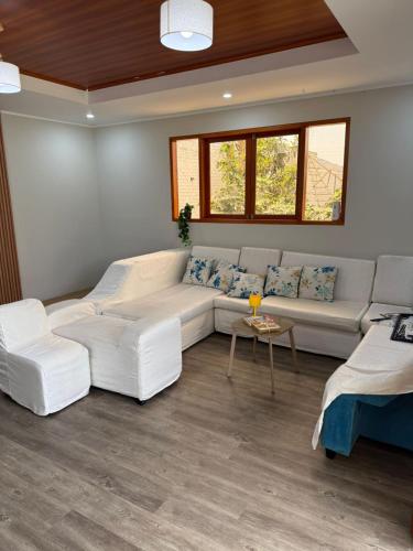 a living room with a white couch and a table at Casa La Herencia in Huaral