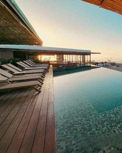 ein Schwimmbad mit Liegestühlen auf einem Gebäude in der Unterkunft Ancora Punta Mita in Punta Mita
