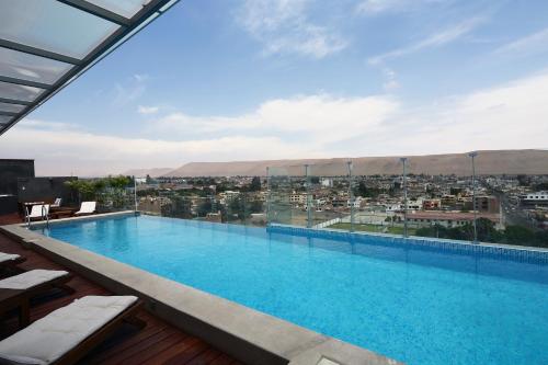 a large swimming pool with a view of a city at Casa Andina Select Tacna in Tacna
