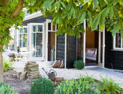 a screened in porch of a black house with a patio at Knechtshuis in Numansdorp