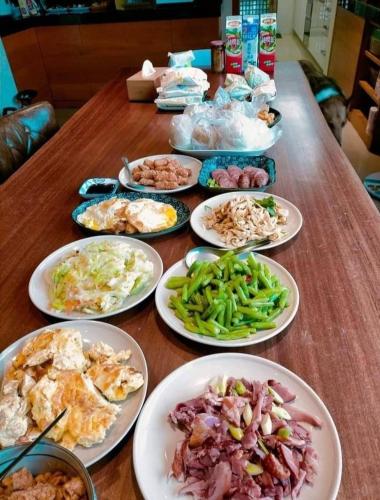 a wooden table with plates of food on it at After the Court Chiaohsi in Jiaoxi