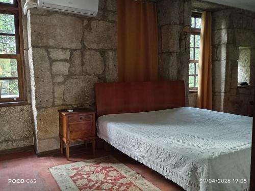 a bedroom with a bed and a table and windows at Quinta Da Lagoa GuestHouse in Vila Real
