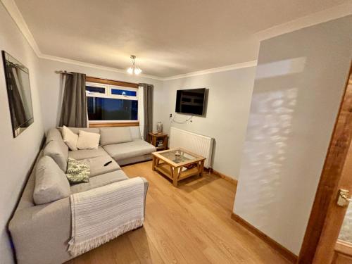 a living room with a couch and a table at Fort William - Highland holiday home in Fort William
