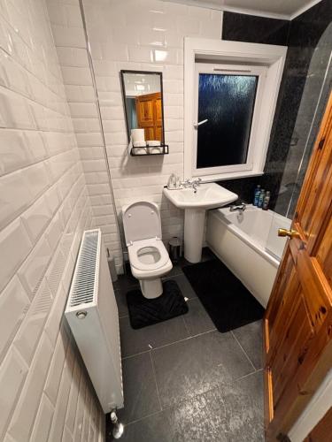a bathroom with a toilet and a sink and a tub at Fort William - Highland holiday home in Fort William