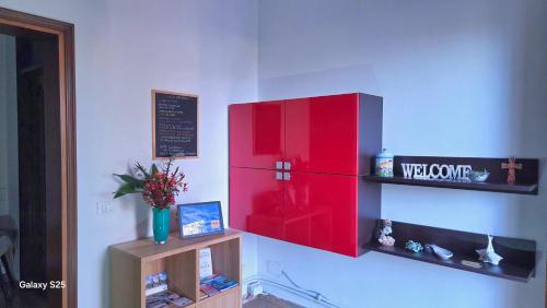 a red refrigerator on a wall with a shelf at Casa Kendra in Montegrotto Terme