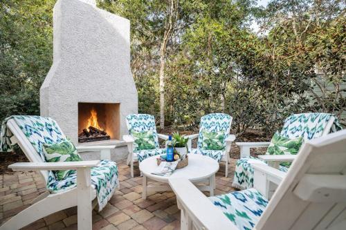 a patio with four chairs and a fireplace at SeaPines on 30A in Santa Rosa Beach