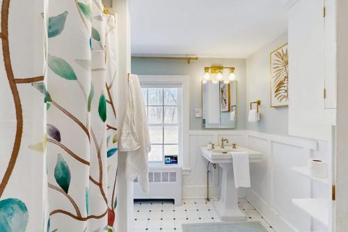 a white bathroom with a sink and a window at The Hilltop in Waterbury