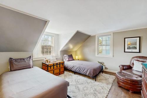 a bedroom with two beds and a couch and a chair at The Hilltop in Waterbury
