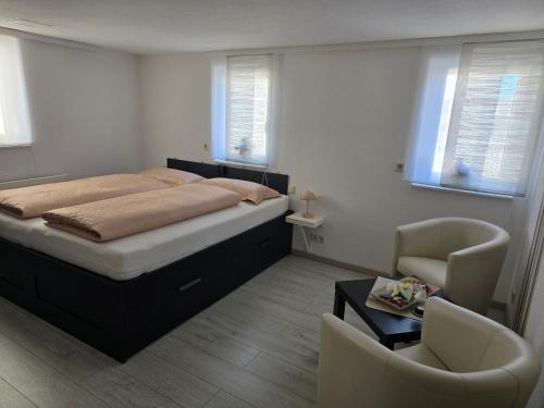 a bedroom with a large bed and a chair at Ferienwohnung Nicole in Schneeberg