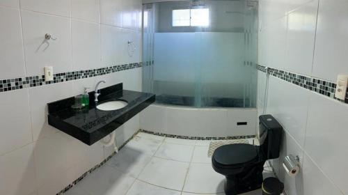 a bathroom with a sink and a shower and a toilet at Casa em jacuma vip in Conde