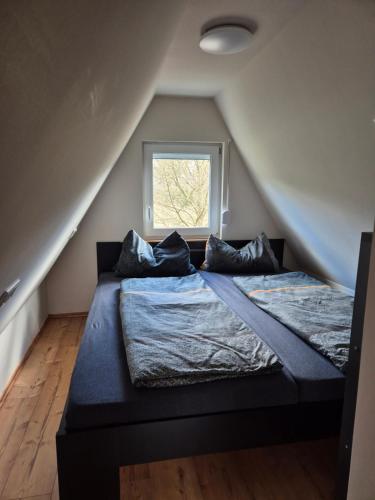 a bedroom with a bed with pillows and a window at Ferienhaus am Helenesee 17 in Frankfurt Oder