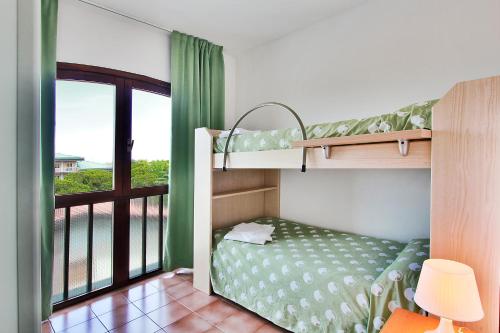 a bedroom with two bunk beds and a balcony at Aparthotel Ponza in Lignano Sabbiadoro