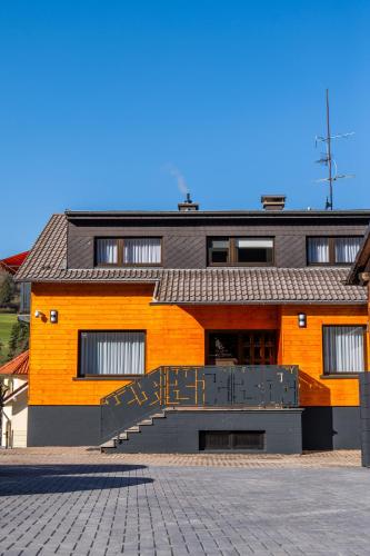 an orange building with a staircase in front of it at Buttermarkt House ``Rooms at the Ring`` in Adenau