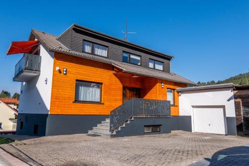 an orange and white house with a white garage at Buttermarkt House ``Rooms at the Ring`` in Adenau
