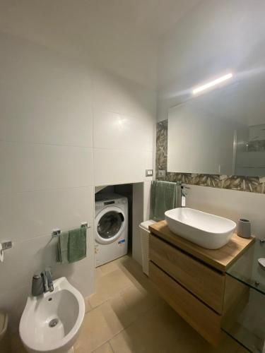 a bathroom with a sink and a washing machine at Nardò apartment in Nardò