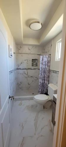 a white bathroom with a toilet and a sink at Cabañas Privadas San Carlos Escape & Relax in Ensenada