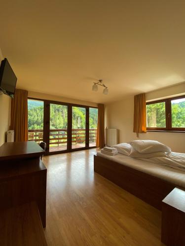a bedroom with a large bed and a large window at Panorama Pietrei Craiului in Zărneşti