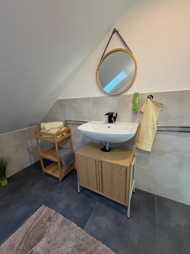 a bathroom with a sink and a mirror at Mira Suites 3 in Schwalbach