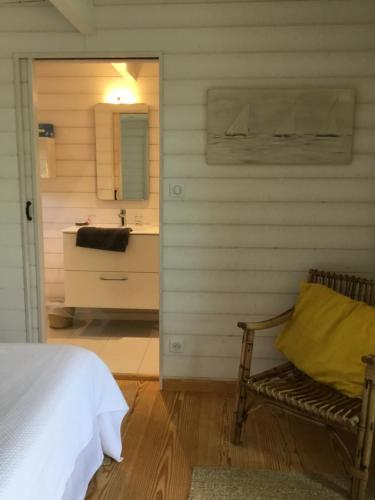a bedroom with a bed and a bathroom with a sink at Cabane dans la verdure in Lège-Cap-Ferret