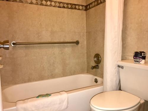 a bathroom with a toilet and a bath tub at Budget Host Inn Florida City in Florida City