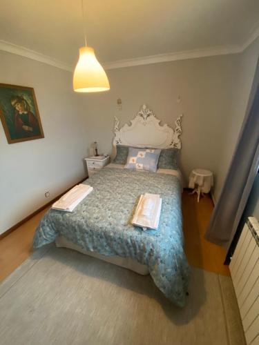 a bedroom with a large bed with a white headboard at A casa das hortênsias- caminho de Santiago in São Pedro da Torre