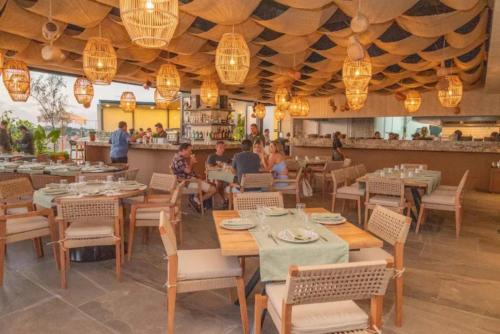 ein Restaurant mit Holztischen und Stühlen und Menschen, die essen in der Unterkunft Ancora Punta Mita in Punta Mita